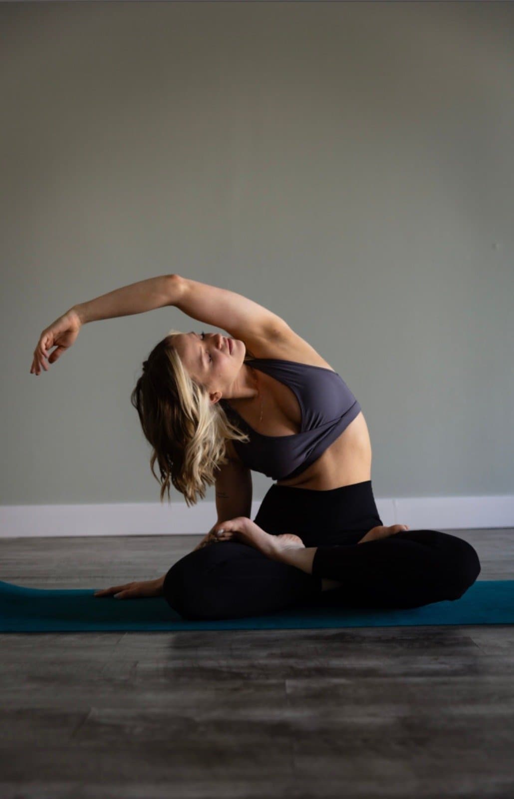 Yoga practitioner seated in a side bend inside the Soul Deep Yoga studio.